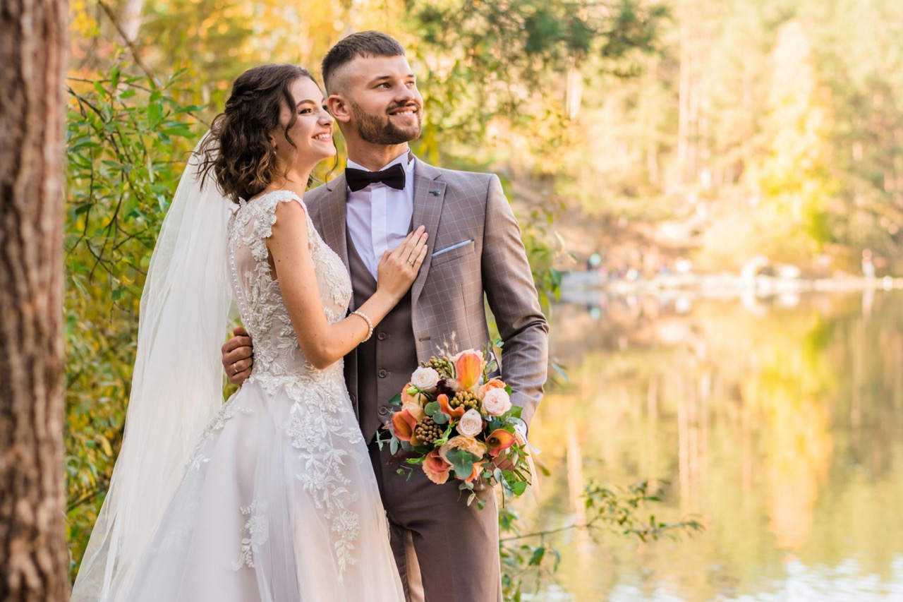 Brautpaar in eleganter Hochzeitskleidung am See